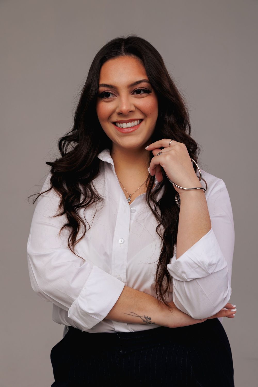 Yasmin Senna, advogada, sorrindo de camisa branca
